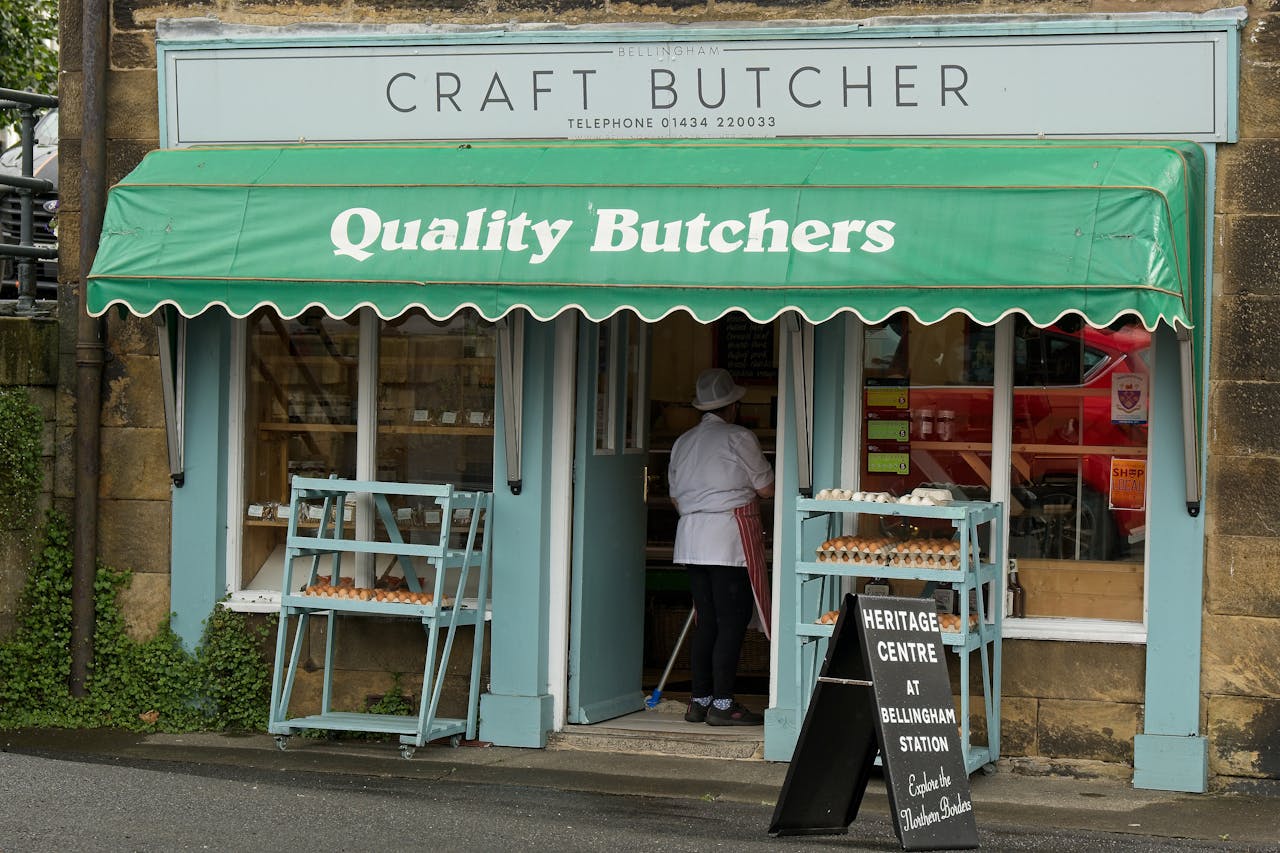 Exterior of a traditional butcher shop in Bellingham, UK, showcasing fresh meat and local produce.